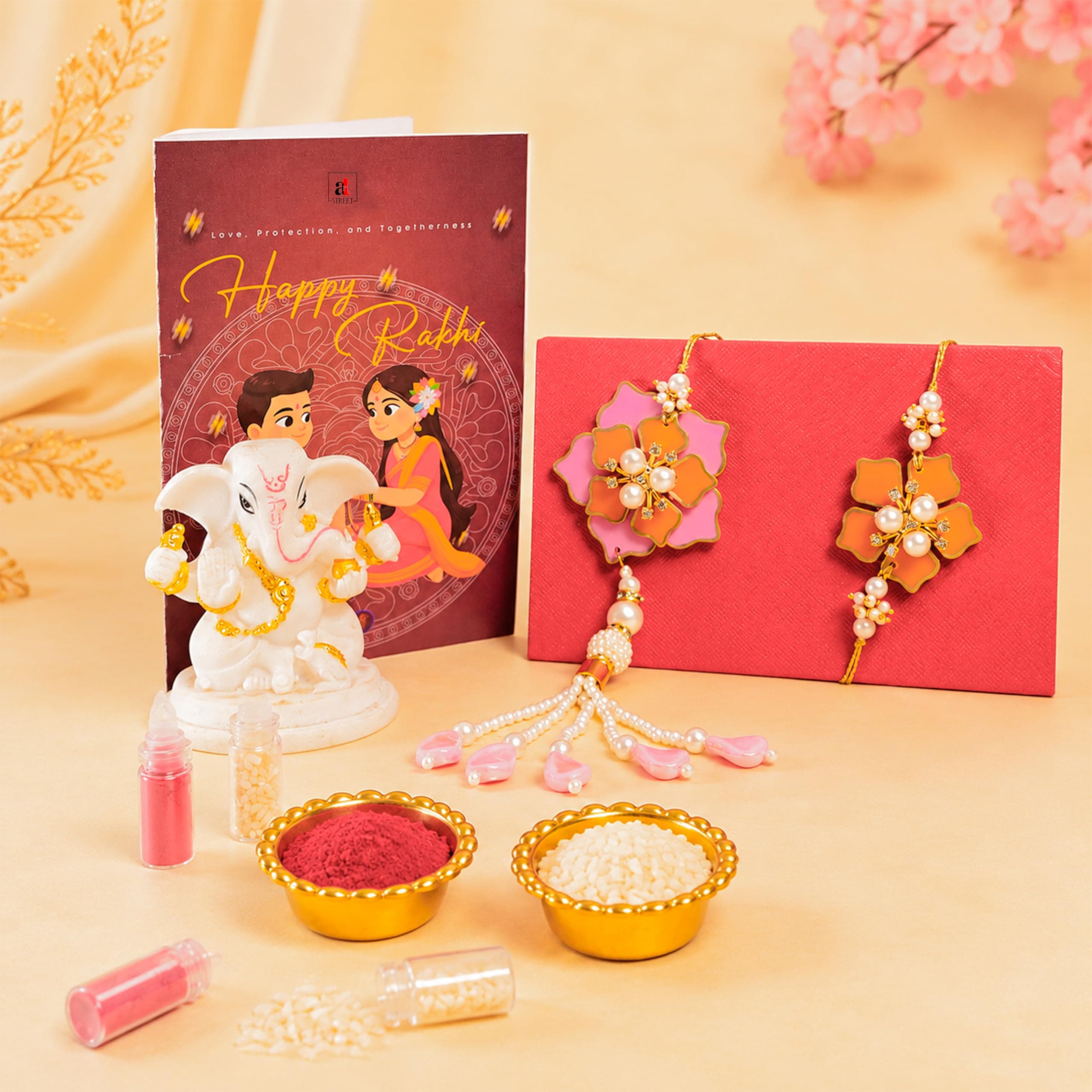 Art Street Bhaiya Bhabhi Rakhi Lumba Set With White Ganesha Idol, Floral Pink Rakhi For Brother & Bhabhi, Greeting Card & Roli Chawal Combo